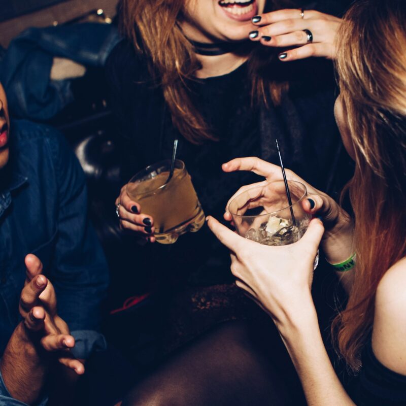 Two guests holding drinks and talking at a networking reception
